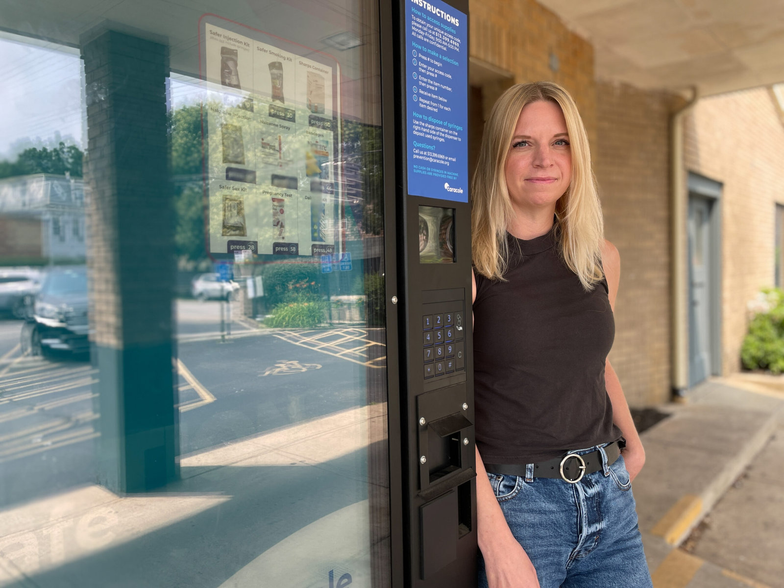 Suzanne Bachmeyer, the director of prevention for Caracole, stands beside a vending machine stocked with naloxone outside the nonprofit organization’s offices in Cincinnati. 